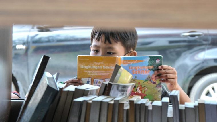 Ilustrasi anak membaca buku di perpustakaan keliling. Foto Merdeka.com