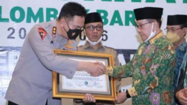 Kapolda NTB, Irjen Mohammad Iqbal (kiri), berjabat tangan dengan Ketua Dewan Penasihat MN KAHMI, Akbar Tandjung, saat penyerahan piagam penghargaan di sela-sela pelantikan pengurus Majelis Daerah KAHMI Lombok Barat, NTB, pada Selasa (14/12/2021). Dokumentasi Polda NTB