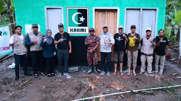 Koordinator Presidium MW KAHMI Jatim, Edi Purwanto atau Edi Ortega (keempat kiri), foto bersama korban erupsi Gunung Semeru yang juga penerima donasi serta pengurus KAHMI dan donatur di sela-sela penyerahan bantuan di Kabupaten Lumajang, Jatim, pada Minggu (13/3/2022). Dokumentasi MW KAHMI Jatim