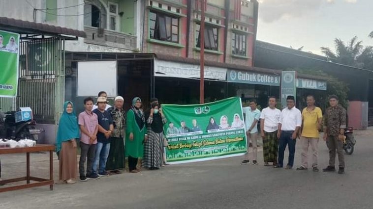 Pengurus MD KAHMI dan FORHATI Padang Lawas serta relawan foto bersama di sela kegiatan berbagi takjil di depan Sekretariat KAHMI Padang Lawas, Sumut, pada Senin (4/4/2022). Foto Newshunter.id