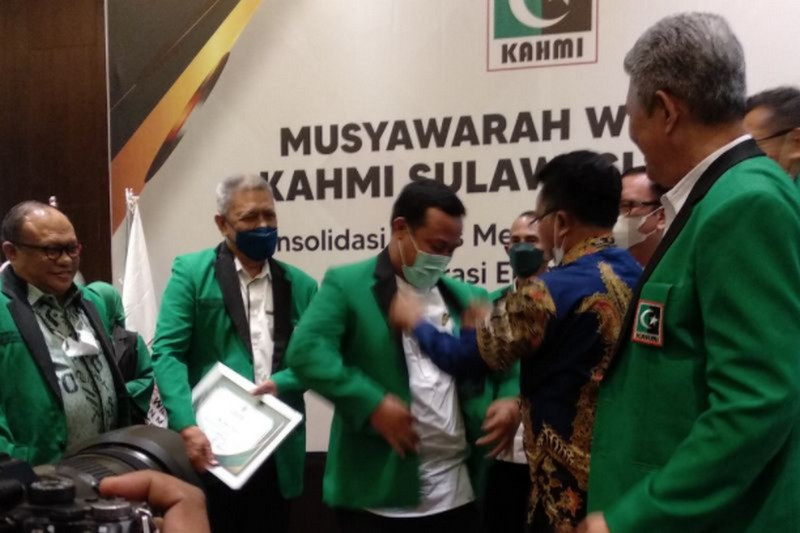 Sekjen MN KAHMI, Manimbang Kahariady (kedua kanan), mengenakan jas hijau hitam kepada Plt Gubernur Sulsel, Andi Sudirman Sulaiman, sebagai tanda resmi menjadi Anggota Kehormatan KAHMI di sela-sela pembukaan Muswil KAHMI Sulsel di Kota Makassar, Sabtu (15/1/2022). Antara Foto/Abdul Kadir